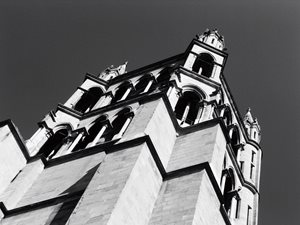 Architektura – černobílá fotografie, členitá historická stavba s arkádami, pohled zdola směrem k nebi
